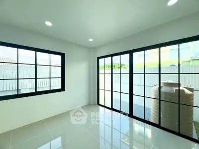 Bright room with large windows and glossy tiled floor, perfect for modern living.