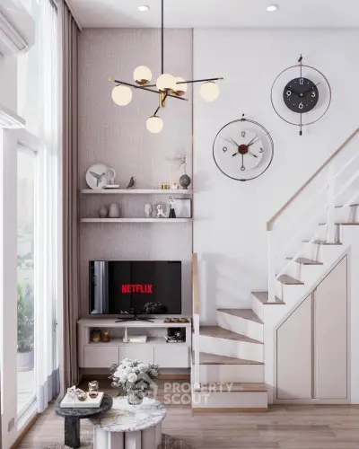Modern living room with stylish decor and staircase, featuring a TV and elegant lighting.