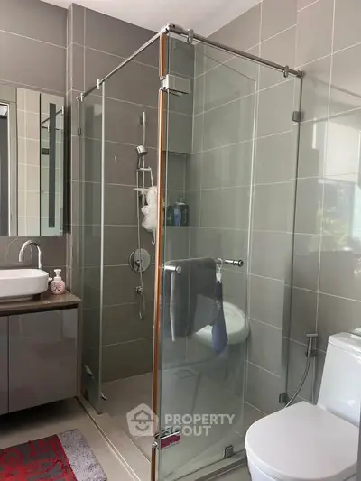 Modern bathroom with glass shower enclosure and sleek fixtures