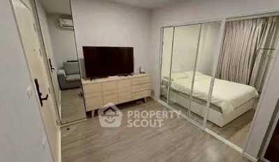 Modern bedroom with sliding glass doors and wooden flooring, featuring a sleek TV setup and cozy bed.
