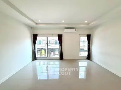 Spacious unfurnished living room with large windows and air conditioning in modern apartment.