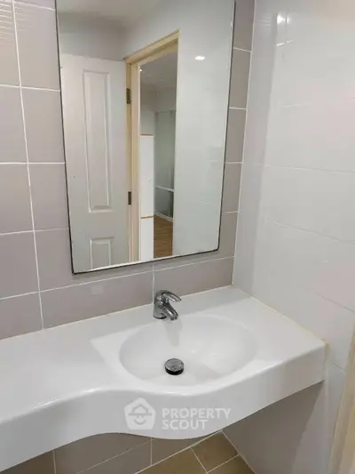 Modern bathroom with sleek sink and large mirror in a contemporary home.