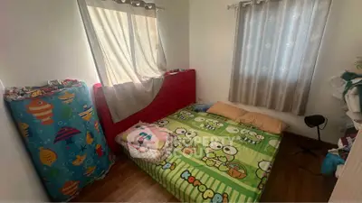 Cozy bedroom with colorful bedding and ample natural light.