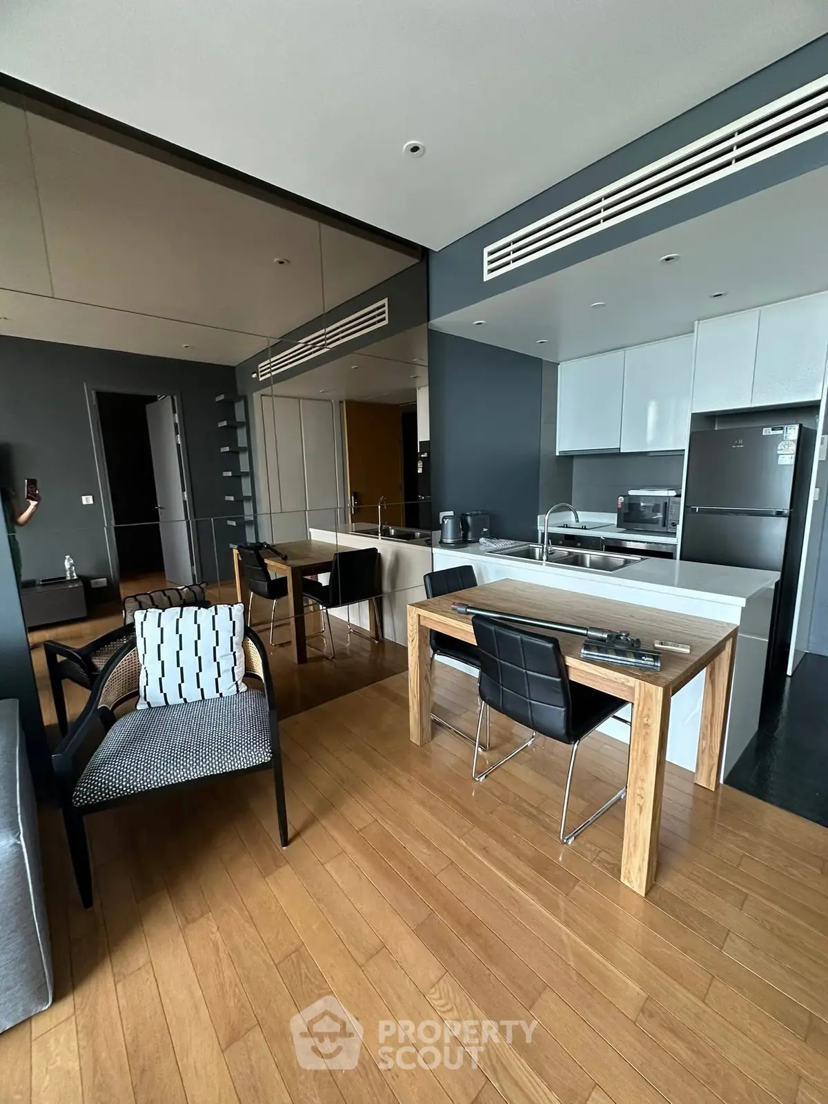 Modern open-plan kitchen and dining area with sleek design and wooden flooring.