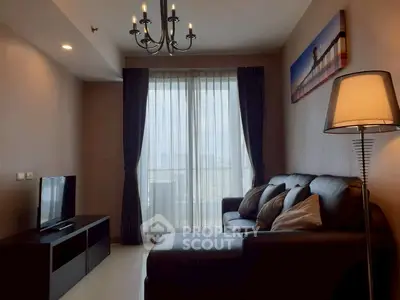 Modern living room with elegant chandelier and cozy sofa, featuring a large window with city view.