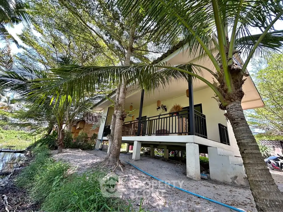 Charming elevated house with lush greenery and tropical surroundings, perfect for serene living.