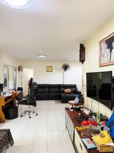 Spacious living room with modern furniture and large TV, ideal for family gatherings.