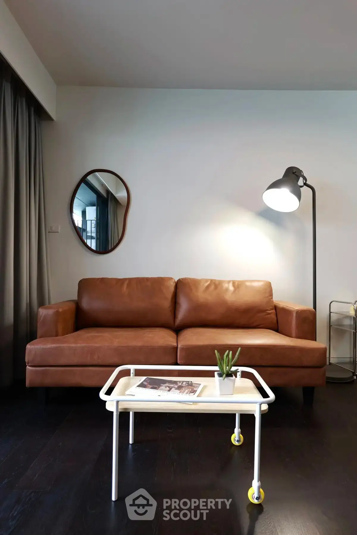 Stylish living room with leather sofa, modern lamp, and sleek coffee table in contemporary apartment.