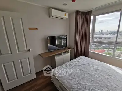 Cozy bedroom with city view, featuring a wall-mounted TV and air conditioning.