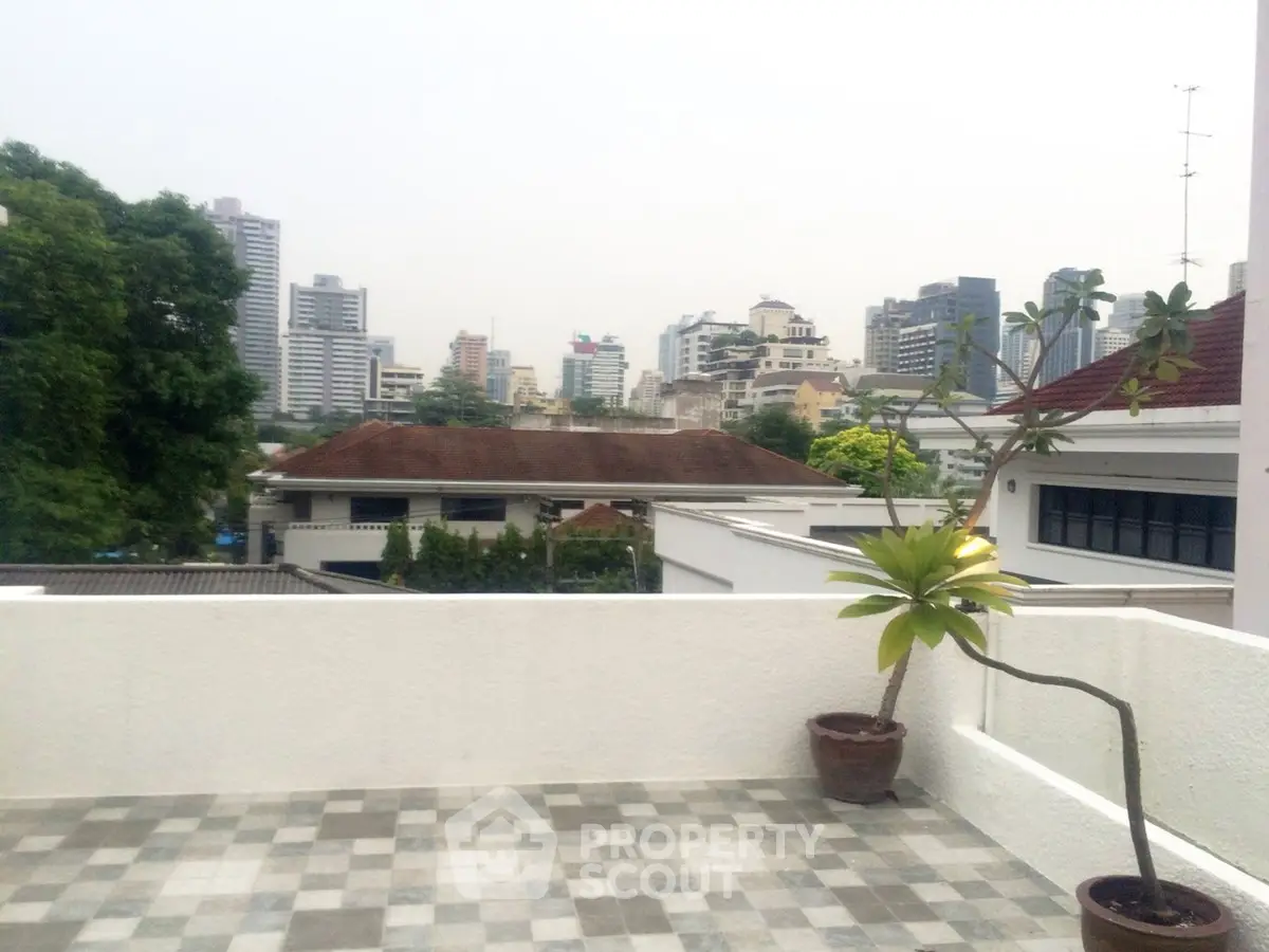 Spacious rooftop terrace with city skyline views and potted plants, perfect for urban living.