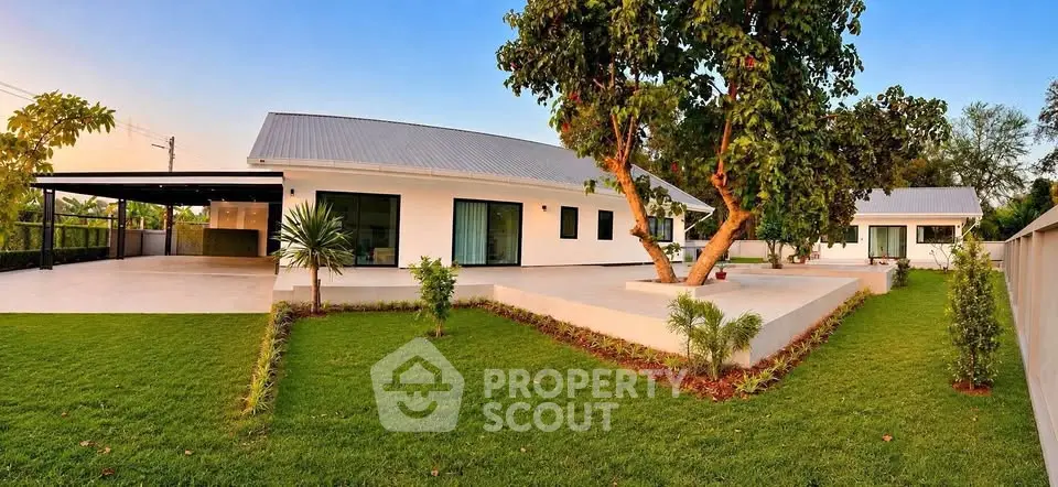 Modern single-story home with lush green lawn and spacious outdoor area, perfect for family living.