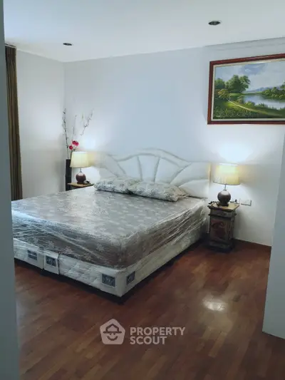 Spacious bedroom with elegant decor and wooden flooring