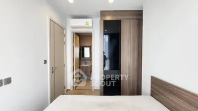 Modern bedroom with ensuite bathroom and sleek wooden wardrobe