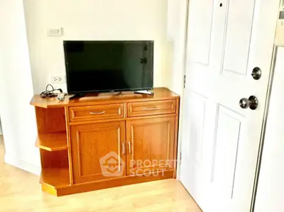 Cozy living room corner with wooden cabinet and TV setup