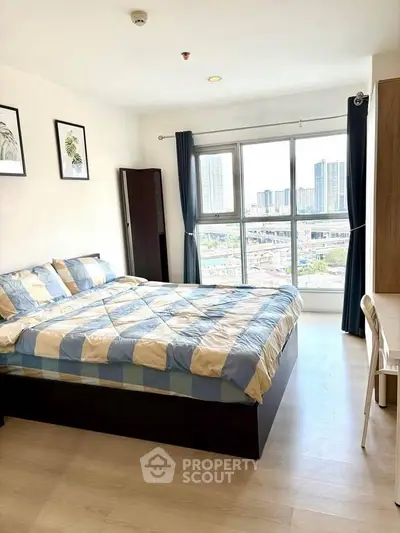Bright bedroom with city view, modern decor, and ample natural light.