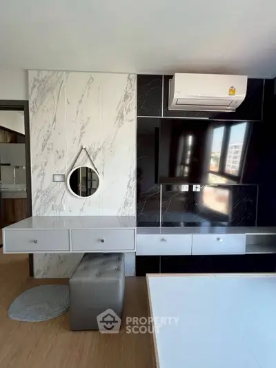 Modern living room with stylish marble wall, mounted TV, and sleek air conditioning unit.