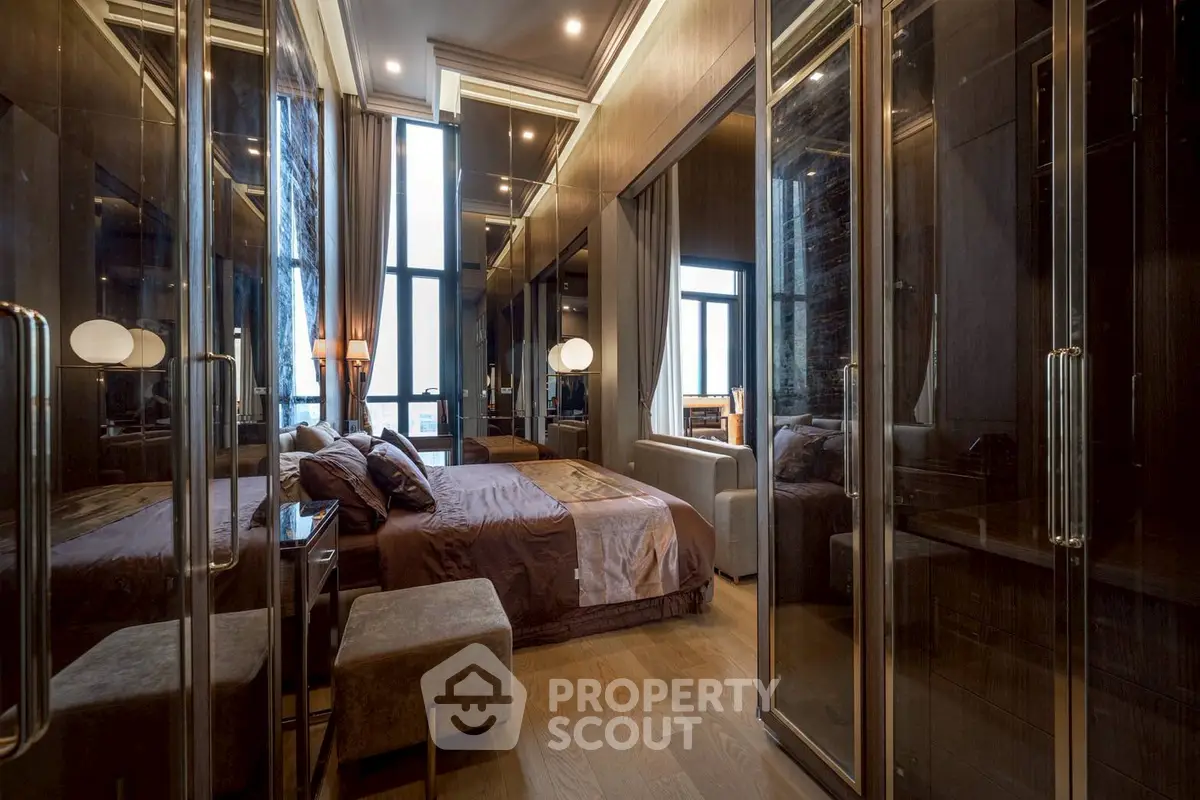 Luxurious bedroom with mirrored closets and elegant lighting in modern apartment.