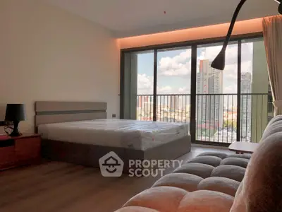 Spacious bedroom with large windows offering stunning city views in modern apartment.