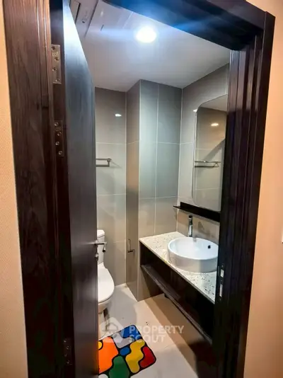 Modern compact bathroom with stylish fixtures and colorful mat