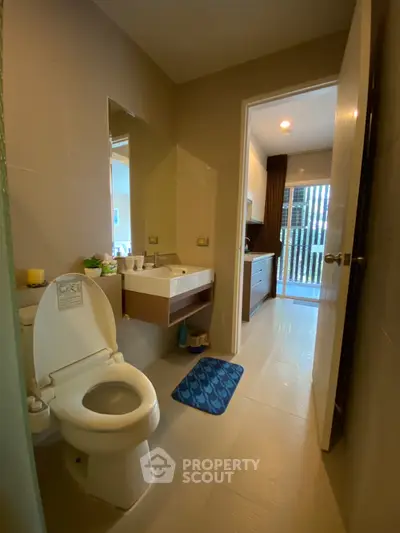 Modern bathroom with sleek fixtures and natural light, featuring a stylish sink and toilet.