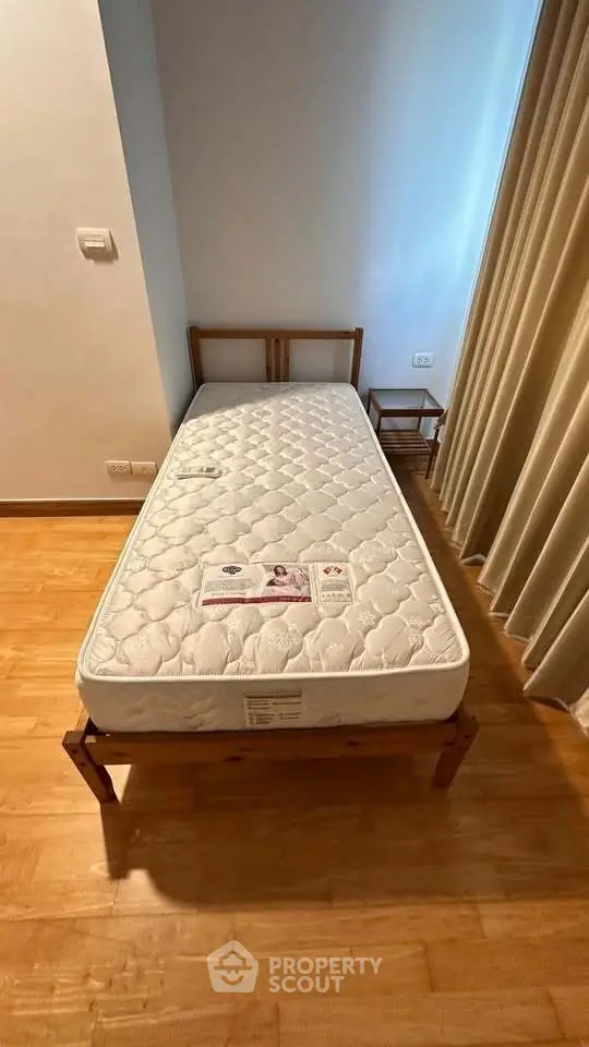 Cozy bedroom with wooden flooring and single bed, perfect for minimalist living.