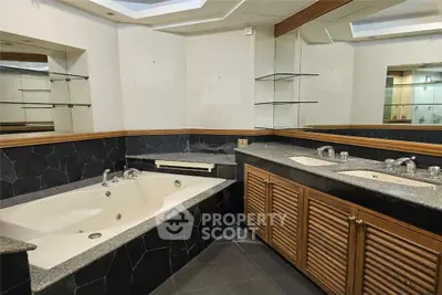 Luxurious bathroom with elegant black stone tiles and spacious bathtub