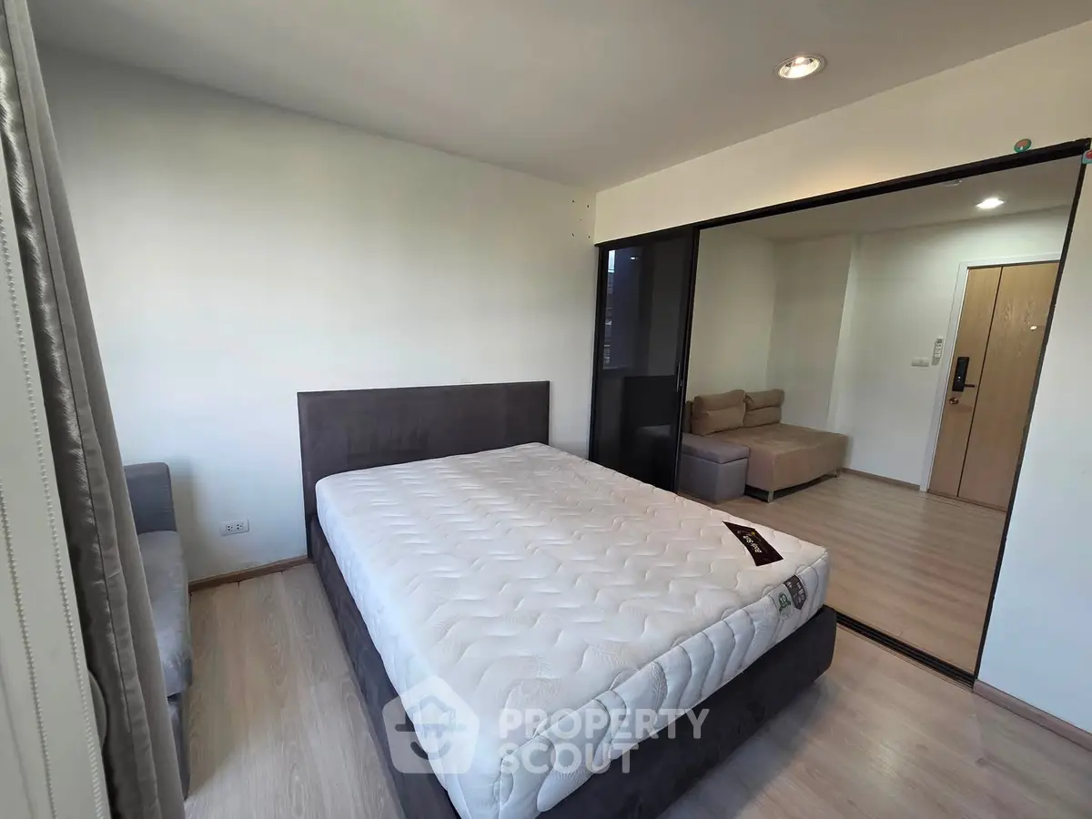 Modern bedroom with sleek design and cozy seating area in contemporary apartment.