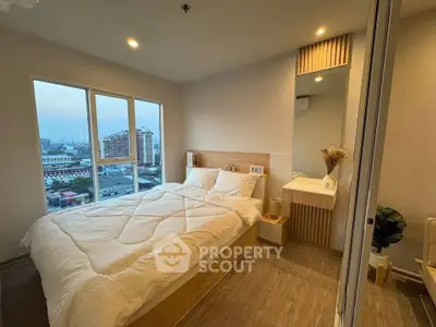 Cozy bedroom with city view, featuring modern decor and ample natural light.