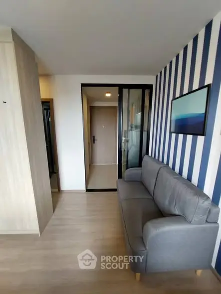 Modern living room with stylish striped wall and cozy gray sofa