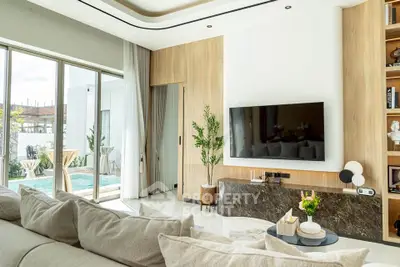 Luxurious living room with pool view, modern decor, and large TV, perfect for relaxation.