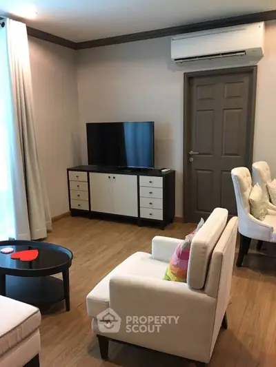 Cozy living room with modern furniture and air conditioning, perfect for relaxation.