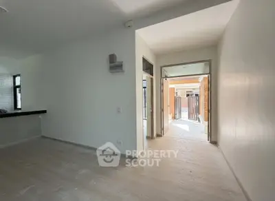 Spacious modern interior with open layout and natural light, leading to a charming outdoor area.