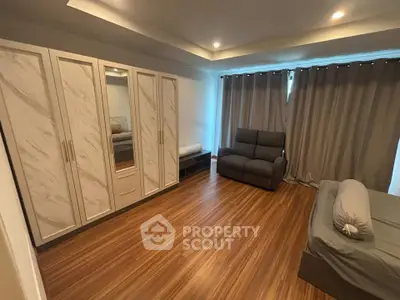 Spacious bedroom with elegant wood flooring and modern furnishings