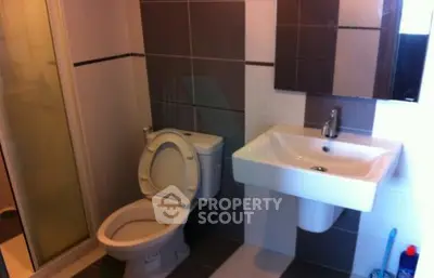 Modern bathroom with sleek fixtures and tiled walls in a contemporary apartment.