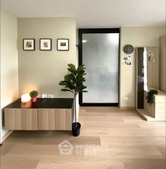 Modern minimalist living room with light wood flooring and sleek furniture.