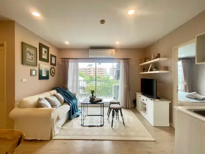 Charming living room with cozy sofa, modern decor, and balcony view in stylish apartment.