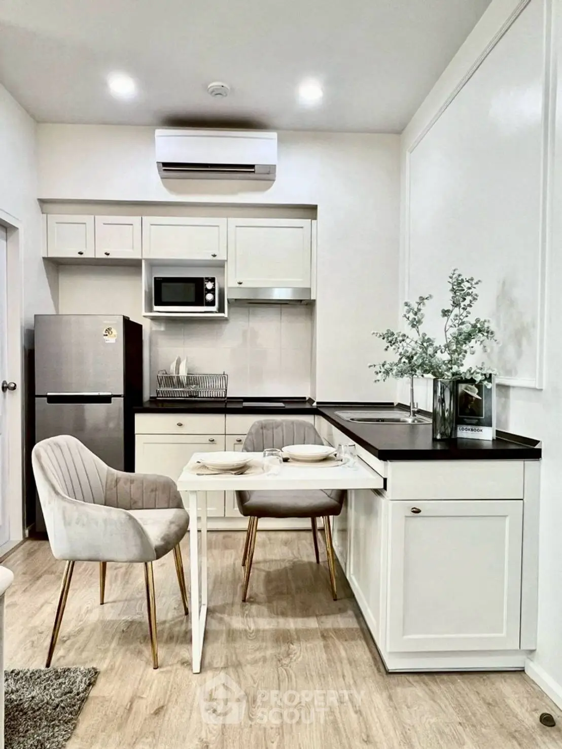 Chic modern kitchen with sleek appliances and cozy dining area, perfect for urban living.