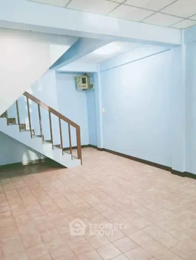 Spacious interior with tiled flooring and staircase, perfect for customization