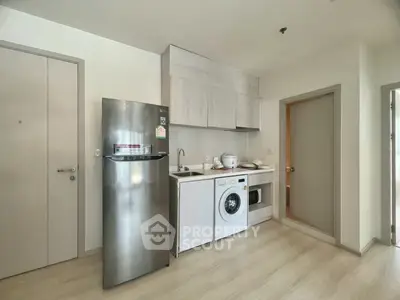 Modern kitchen with sleek appliances and wood cabinetry in a stylish apartment.