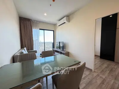 Modern living room with glass dining table and city view from balcony