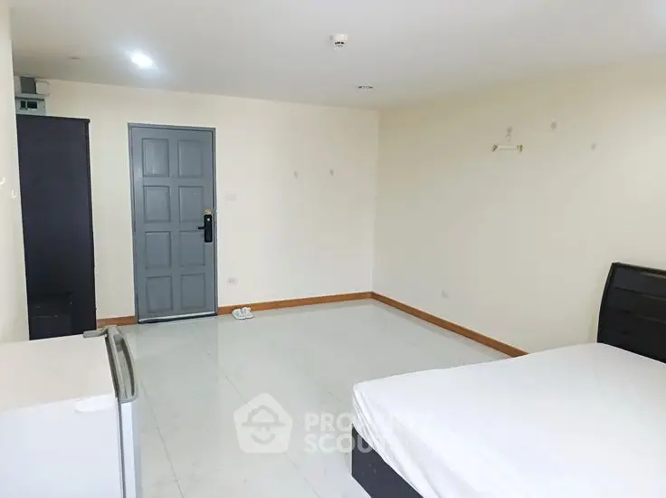 Spacious minimalist bedroom with modern furnishings and ample natural light.