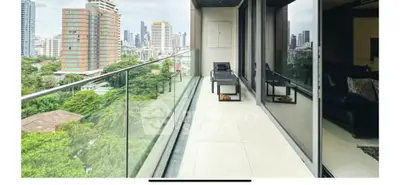 Luxurious high-rise balcony with stunning city skyline view and modern glass railing.
