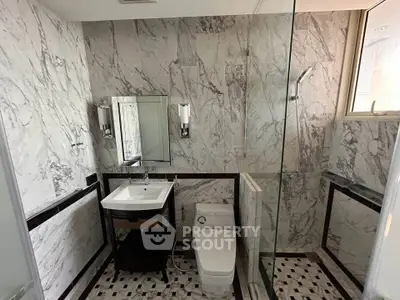 Luxurious marble bathroom with elegant fixtures and glass shower enclosure