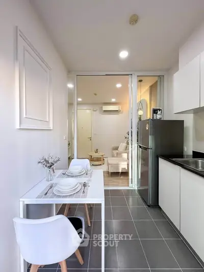 Modern open-layout kitchen with dining area and view into cozy living room