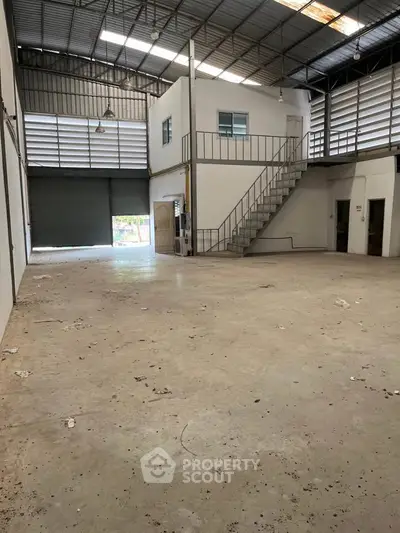 Spacious industrial warehouse with high ceilings and mezzanine office space.