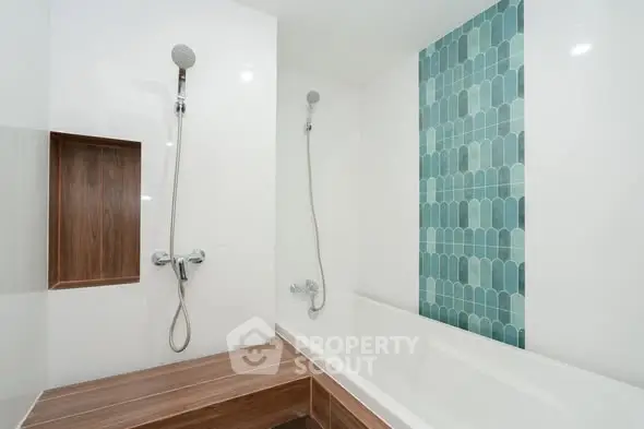Modern bathroom with stylish blue tile accent and dual shower heads