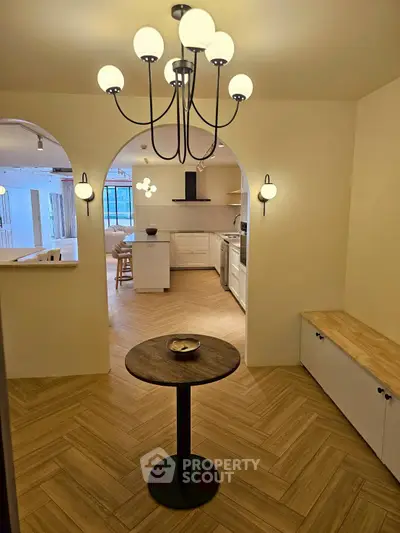 Charming open-layout kitchen with elegant lighting and cozy dining area.
