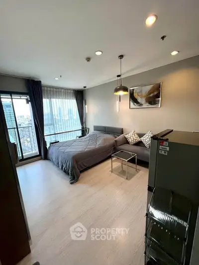Modern bedroom with city view, featuring sleek decor and large windows for natural light.