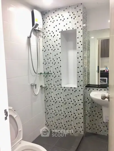 Modern bathroom with stylish mosaic tiles and sleek fixtures in a contemporary apartment.