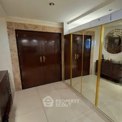 Elegant entryway with mirrored closet doors and polished wooden accents